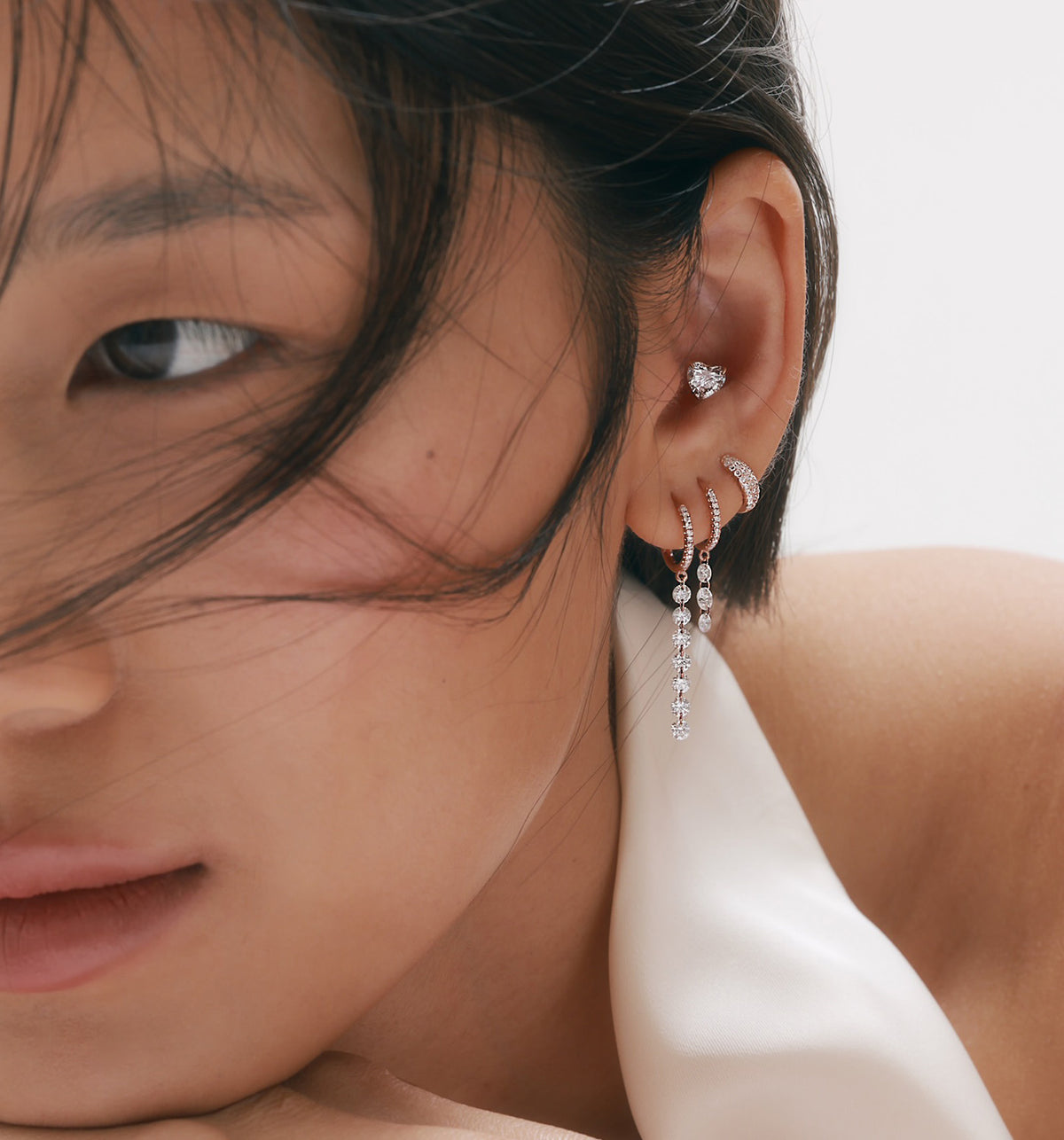 0.55ct heart-shaped lab-grown diamond piercing earring styled with multiple lobe earrings on model