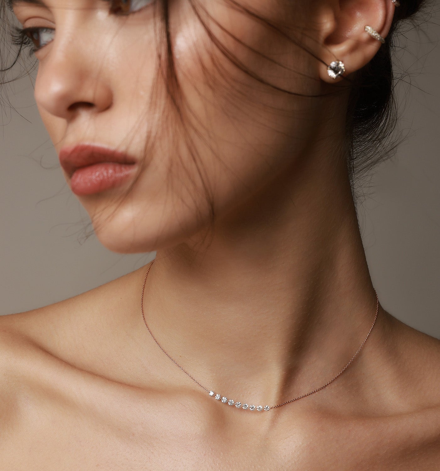 CVD lab diamond stud earrings 2 carat each set in rose gold worn on a model’s ear