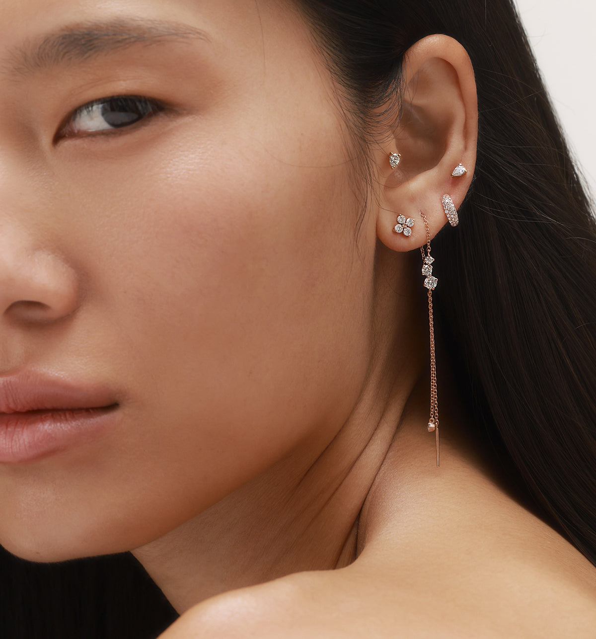 Honey Ariel and Mini Poffy earrings styled with two natural pear-shaped diamond piercing earrings in a five-earring composition on model