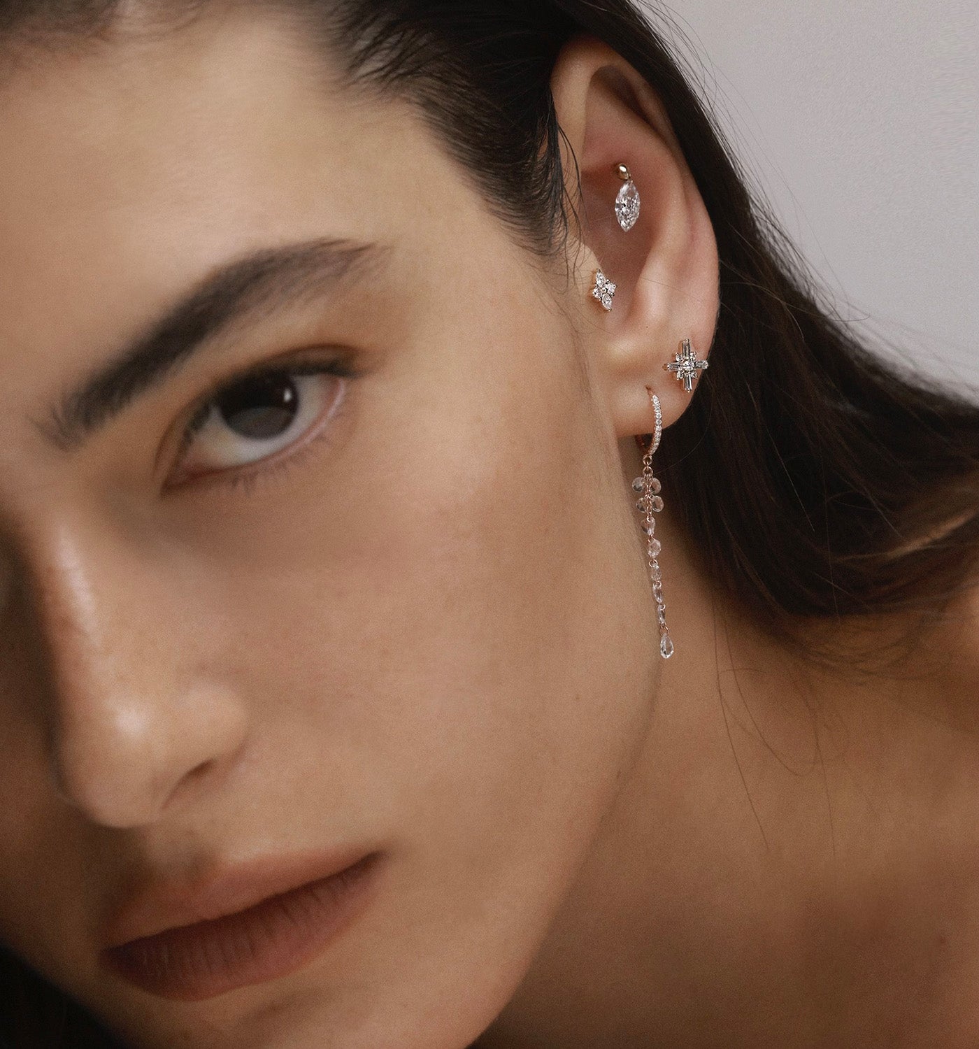 Miro piercing labret earring in rose gold set with natural diamonds worn on a model’s ear