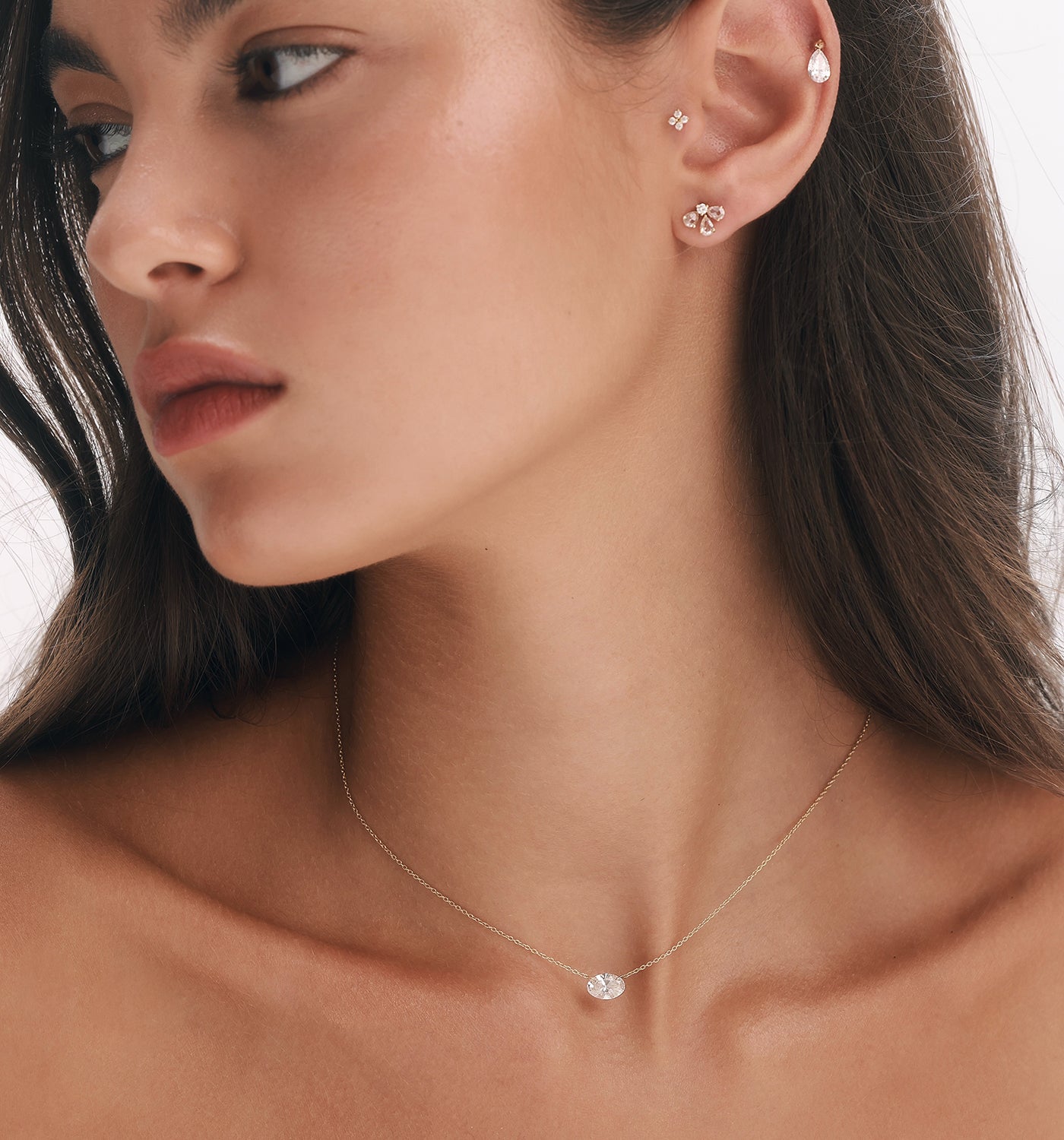 ALT TEXT:
דוגמנית עונדת שרשרת OVAL SHAPE FLOATING LAB DIAMOND NECKLACE מזהב צהוב, בשילוב עגיל GIA, עגיל הליקס עם יהלום מעבדה צף בצורת טיפה ועגיל FOUR בטרגוס, ליצירת מראה Ear Styling עדין ומשובץ יהלומים.