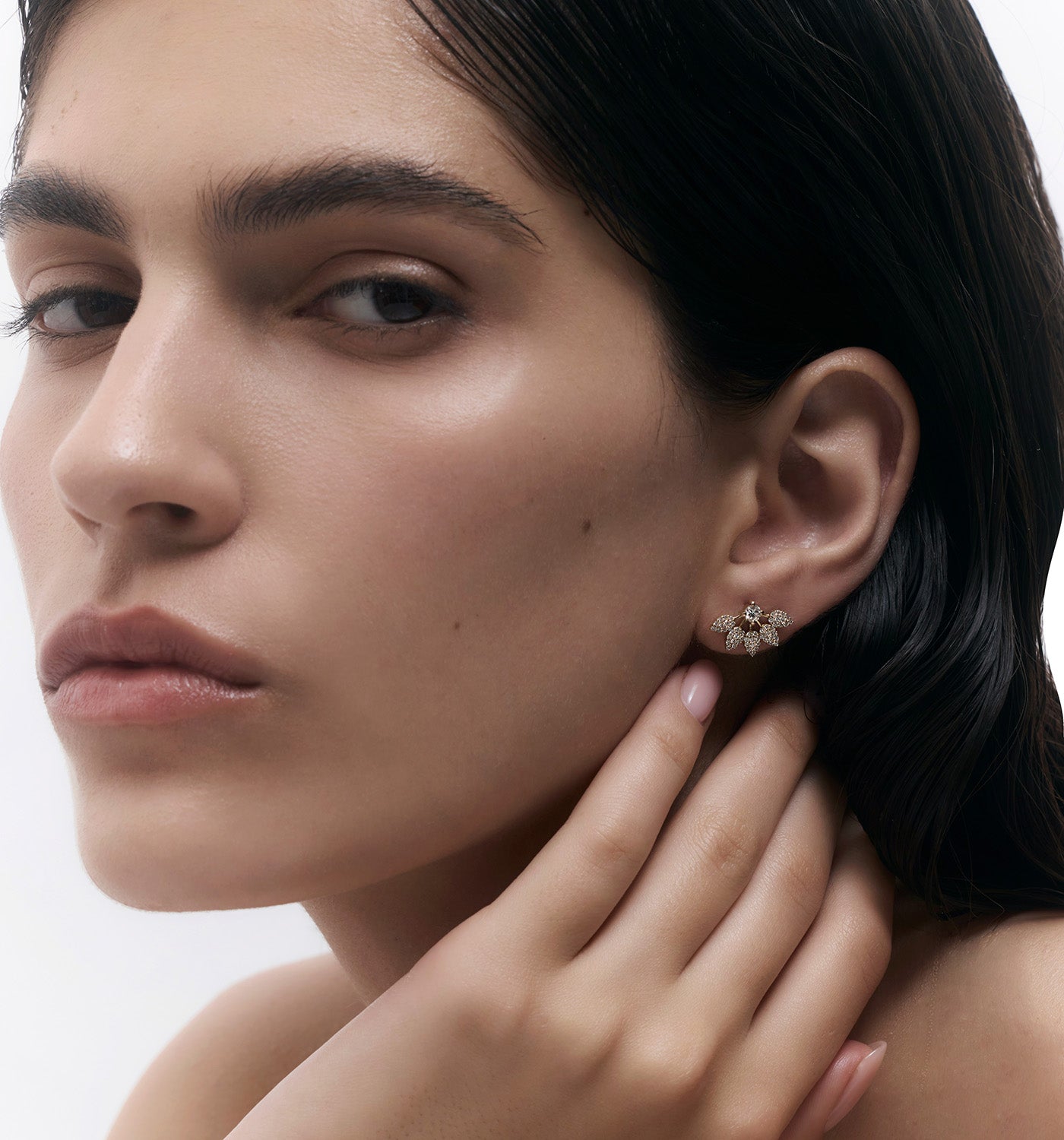 Sisi stud earring in yellow gold set with natural diamonds worn on a model’s ear