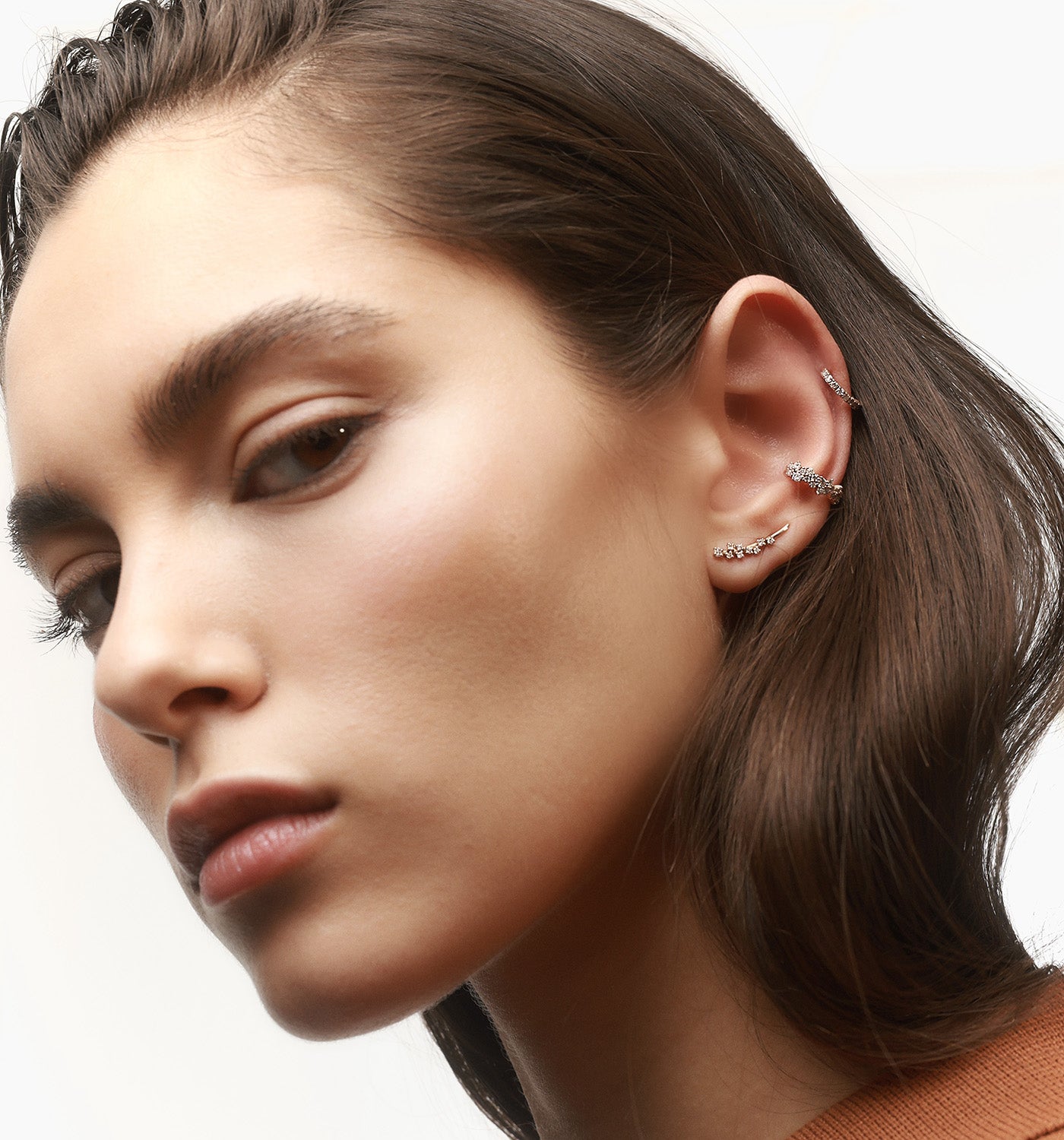 Ariel ear cuff in rose gold set with natural diamonds worn on a model’s ear