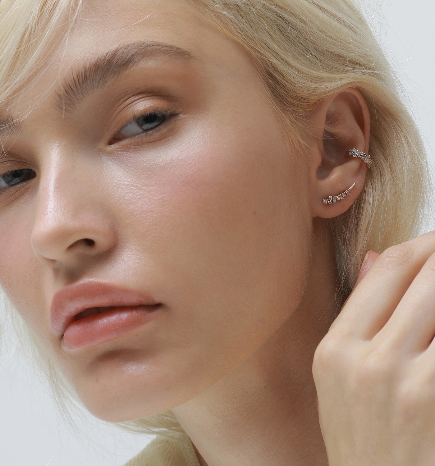 Ariel ear cuff in rose gold set with natural diamonds worn on a model’s ear
