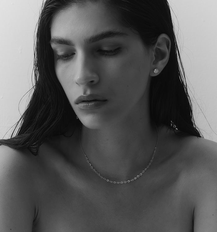 CVD lab diamond stud earrings 1 carat each set in yellow gold worn on a model’s ear