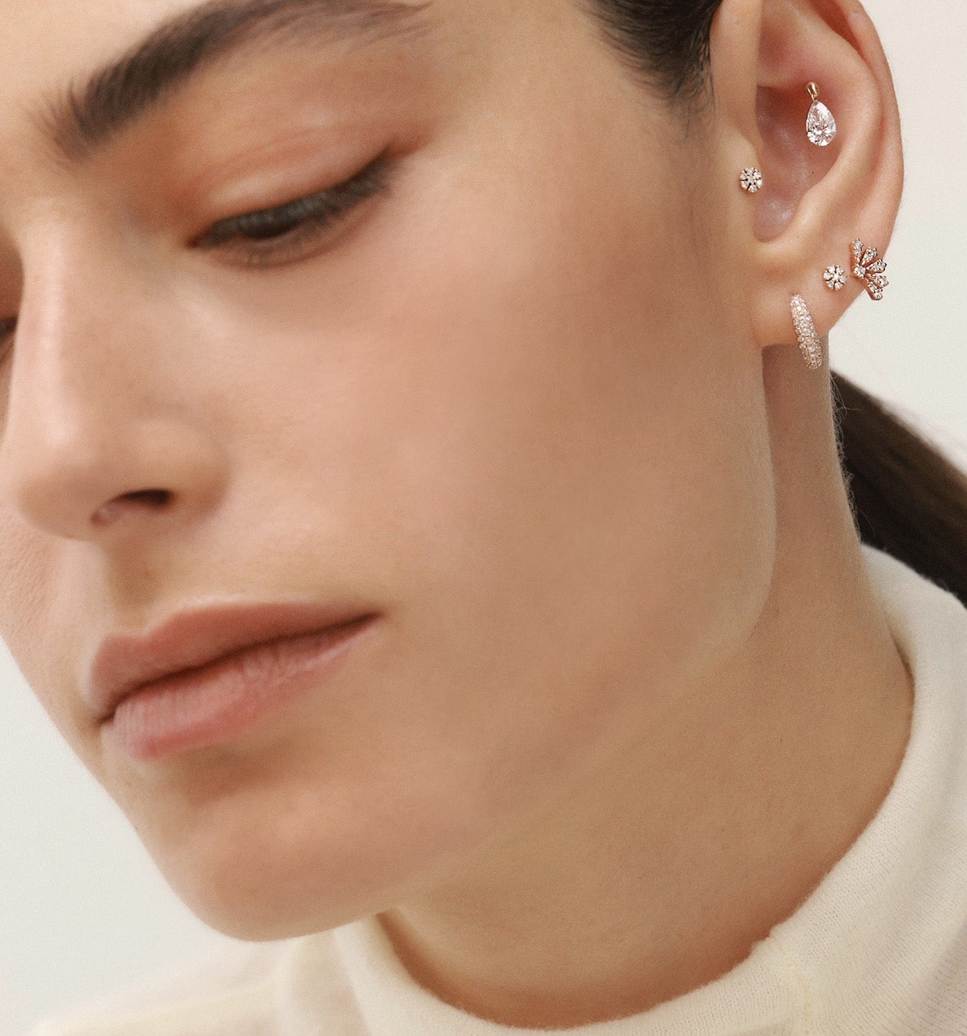 Petit piercing labret earring in rose gold set with natural diamonds worn on a model’s ear