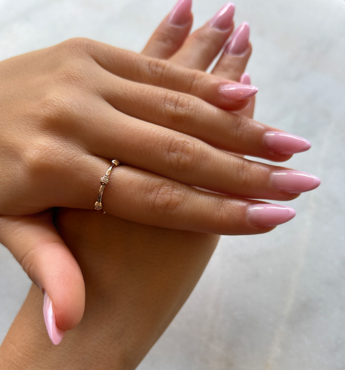 Shani eternity ring in rose gold set with natural diamonds worn on a model hand