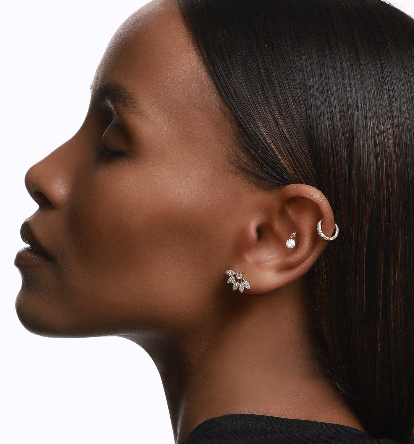 Sisi stud earring in yellow gold set with natural diamonds worn on a model’s ear