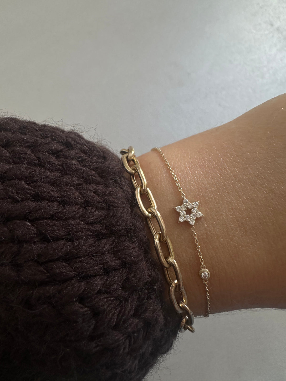 Star of David bracelet in rose gold set with natural diamonds worn on a model’s hand